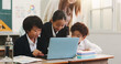 © K.A./peopleimages.com - Children, laptop and teacher in classroom for education, reading and happy with project at academy. People, kids and computer with studying, scholarship and e learning with guide at school in Japan