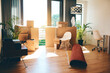 © CamPen2000/peopleimages.com - Boxes, furniture and empty home or modern apartment with property, mortgage or real estate background for moving in. Living room, lounge and new house with interior or space for relocation in USA