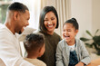 © peopleimages.com - Family, laughing and parents with children in home with joke, bonding and love together with comedy. Support, mother and father with communication, smile and happy talk with care and fun in lounge