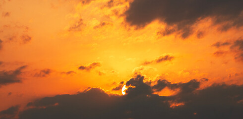 Wall Mural - sun sets behind the clouds, beautiful bright sunset sky with dramatic clouds. sunset sky background.