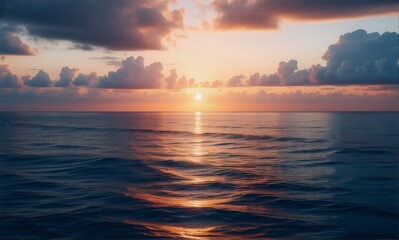 Aufkleber - Golden hour paints the sky as the sun dips below the horizon, casting a warm glow on the tranquil ocean and softly rippling water under a cloudy sky.