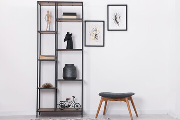 Aufkleber - Shelving unit with different home decor and chair near white wall indoors