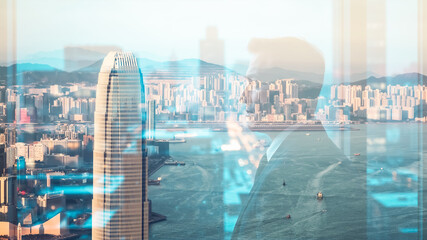 Fototapete - A double exposure blends a person in a suit with a cityscape view of Hong Kong.  Urban architecture and harbor scene are visible through the silhouette.