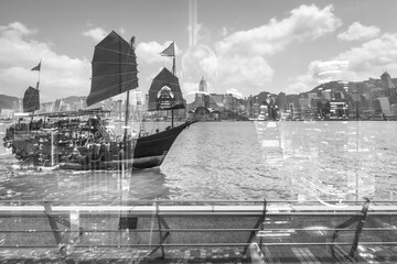 Aufkleber - Hong Kong cityscape with double exposure effect showcasing a traditional junk boat sailing on water, blended with urban buildings under a cloudy sky.
