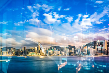 Fototapete - Hong Kong cityscape with a double exposure effect. The bright skyline blends with the sky and water in an abstract yet urban view.