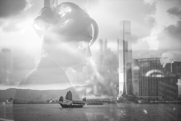 Poster - A double exposure image blending a person's silhouette with a Hong Kong cityscape.  Boats sail on the water in this monochrome, layered, artistic scene.
