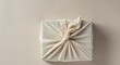 © Sister - Eco-friendly gift wrapped in furoshiki fabric with knot on neutral background