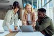 © bnenin - Diverse Team Collaborating on a Project Around a Laptop in a Modern Office