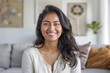 © Markus Schröder - Portrait of a cheerful indian woman in her 30s smiling at the camera in front of crisp minimalistic living room