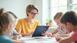 © Radorog. - the teacher is reading a book on a tablet, the children are writing students in a notebook, a lesson at school