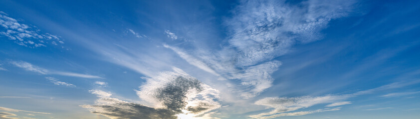 Wall Mural - blue sky with a few clouds and a sun shining through them