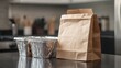 © Katy - A takeout paper bag and disposable food containers are placed on a kitchen counter, showcasing a convenient meal option for busy lifestyles