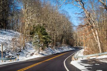 Wall Mural - Winter snow in Maryland state near West Virginia with forest nature trees and nobody on empty road point of view pov