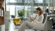 © Marin Studio - Professional woman in modern office using a mobile device, showcasing work-life balance with comfortable workspace.