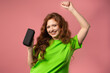 © kohanova1991 - Young woman dancing, listening to music by wireless portable speaker on pink