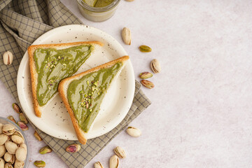 Wall Mural - Plate and bread pieces with tasty pistachio paste on light background