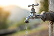 © HaniRaza - stary kran z kapiącą wodą,Brass water tap in nature background,The Tap With Dropping Water,Concetto di spreco delle risorse idriche, fonte nel desrto con poca acqua, rubinetto che perde acqua, spreco