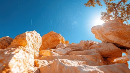 Poster - Low angle view of sandstone rock formation with sunburst sky scenic and warm lighting conditions in daytime. Staircase-like arrangement of rocks with blue sky