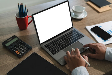 Wall Mural - businessman is sitting at a desk in a modern office with a laptop. the laptop screen is blank