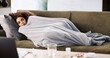 © peopleimages.com - Laptop, sick and relax with woman on sofa for medical recovery, streaming and flu season. Disease, subscription and fever with female person and blanket in living room at home for virus outbreak