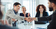 © peopleimages.com - Happy, business people and applause with handshake for good deal, partnership or agreement at conference. Businessman, colleagues or employees shaking hands with team for introduction at workplace