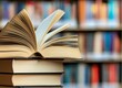 © firdan - Open Book Resting Atop Stack in Library Shows Learning and Knowledge