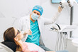 © Maria Vitkovska - Male stomatologist in uniform taking visional inspection of woman on the chair in dental clinic