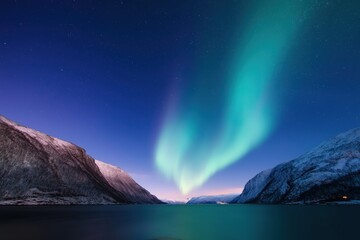  A beautiful night sky with a bright green aurora borealis. The sky is clear and the stars are shining brightly. The mountains in the background add to the serene and peaceful atmosphere