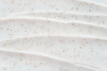 smooth white cream texture with exfoliating brown specks for skincare and beauty products.