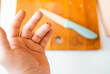 © Victoria - Close-up of a man's  finger cut in blood with a kitchen knife on a background. Injured finger with bleeding open cut wound.