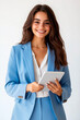 © GraysonStock - Elegant young Hispanic business woman standing holding a tablet smiling and looking at the camera, cut out white background