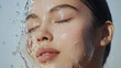 © PhotoLuxeStudio - Asian woman with closed eyes is splashed with water, highlighting her smooth skin and fresh appearance
