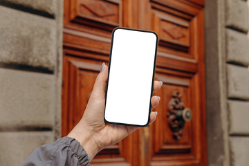 mockup female hand holding using smart phone with white blank screen pov at on the background of a h