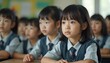 © Pete - Group Japanese elementary school pupils in classroom. Cute girls study, look at lesson. Children in school uniform, close-up faces, focused, concentrated. School concept. Back to school, education in