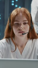 Wall Mural - attractive ginger customer support worker wearing headset speaking microphone servicing client at da