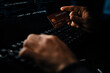 © InfiniteFlow - Cropped hands image in criminal anonymous male approaching credit card of personal information database for codding encryption scam program in privacy system at night at blue neon light room. Surmise.