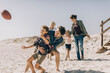 © Marko Geber - Multigenerational family playing football and having fun on a sandy beach on their vacation