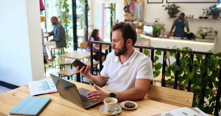 Poster - Man, cafe and laptop with phone call for remote work, financial consultant and communication. Entrepreneur, freelancer and graph discussion for feedback, networking or business project at coffee shop