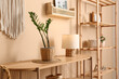 © Pixel-Shot - Wooden table with lamp and houseplant near beige wall in room