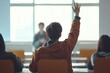 © OGGYA - A young student raises his hand to answer the teacher's question in class