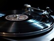 © Hafiz - Black vinyl record on turntable with moody lighting and negative space on side