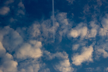 Wall Mural - blue sky with white clouds and airplane trail. cloudscape background.