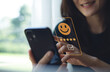 © tippapatt - Customer review satisfaction feedback survey concept. Customer pressing smile face and five star on mobile phone for customer review. Customer satisfaction survey, service experience rating