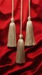 © Postproduction - Tassels of gold flutter on a red silk surface, lending an elegant visual flow. Vertical.