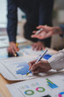 © Phimwilai - Business team analyzing financial charts and graphs, pointing at statistics and discussing company strategy during a meeting, working together on market research and investment planning