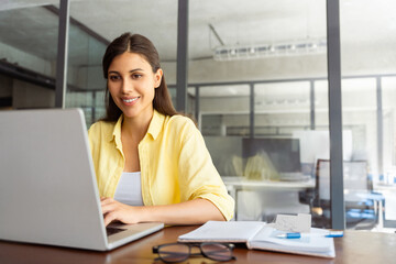 smiling latin hispanic female marketing manager, professional it specialist working, browsing at lap