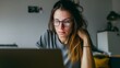 © Marin Studio - Woman with glasses intensely staring at laptop, showcasing focused work or late-night project completion, digital lifestyle.