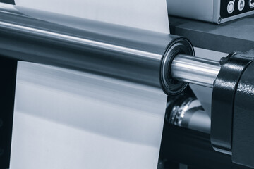 Poster - A machine is weaving a piece of fabric. The machine is made up of many parts, including a large metal piece that is connected to a hose