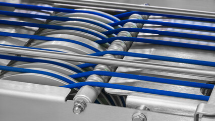 Aufkleber - A conveyor belt with blue and silver stripes. The belt is moving and the image is in black and white