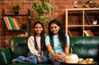 © StockImageFactory - Happy Indian mom and little girl pose together on sofa, smiling and enjoying indoor time